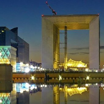 la defense business district outside paris with the grand arch at night
